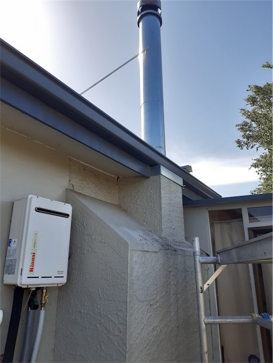 Repaired chimney flashing on a long-run steel roof